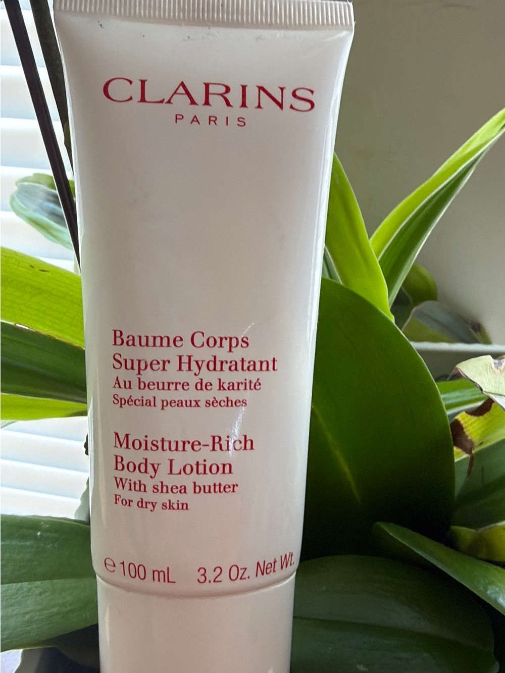 Clarins White Tube Body Care with Red Text